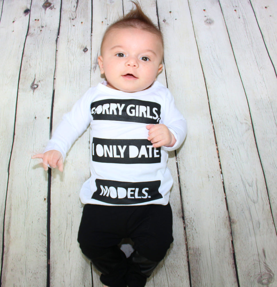 
            
                Load image into Gallery viewer, &amp;quot;Sorry girls, I only date models&amp;quot; This adorable baby boy 2 pieces set is for the little heart breakers. This set comes with the long sleeve shirt with graphics and pants with faux leather on the knees. Keep your little man super stylish and comfy during this Fall season. 
            
        
