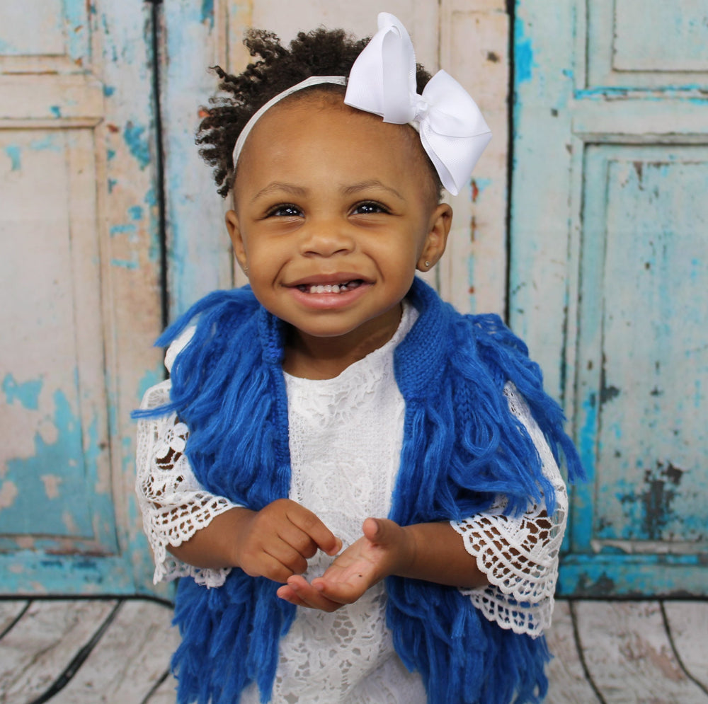 Dress your mini Diva's in this gorgeous blue pop of color for the upcoming Fall season. This vest has hooks that fasten the front closed. The Blue Fringe Vest is light and can be worn underneath a jacket if need be.