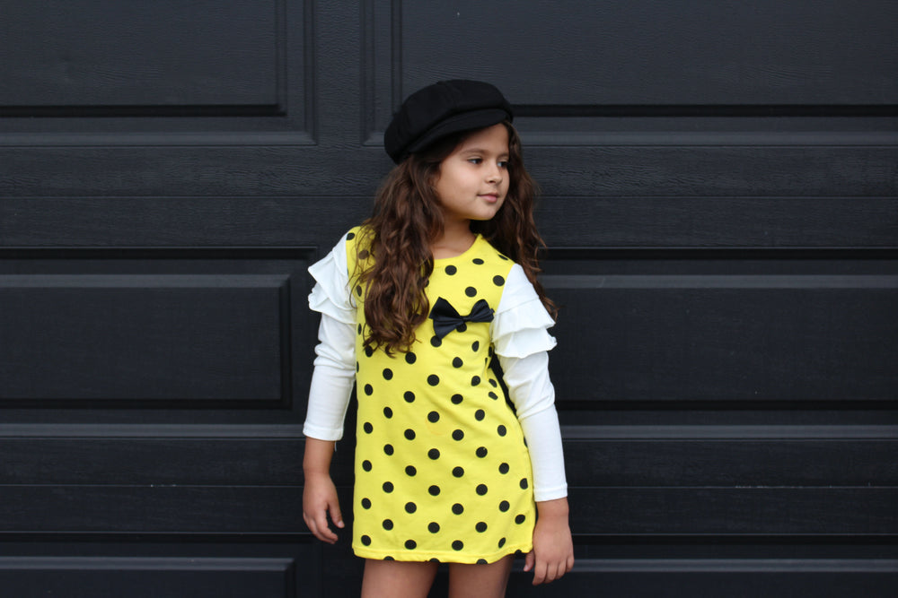 
            
                Load image into Gallery viewer, This fun polka dot dress is the perfect piece for a party! We have two vibrant colors in stock -Pink and Yellow. Both colors have long sleeves attached with ruffles on the shoulders. A bow sits on the left chest.
            
        